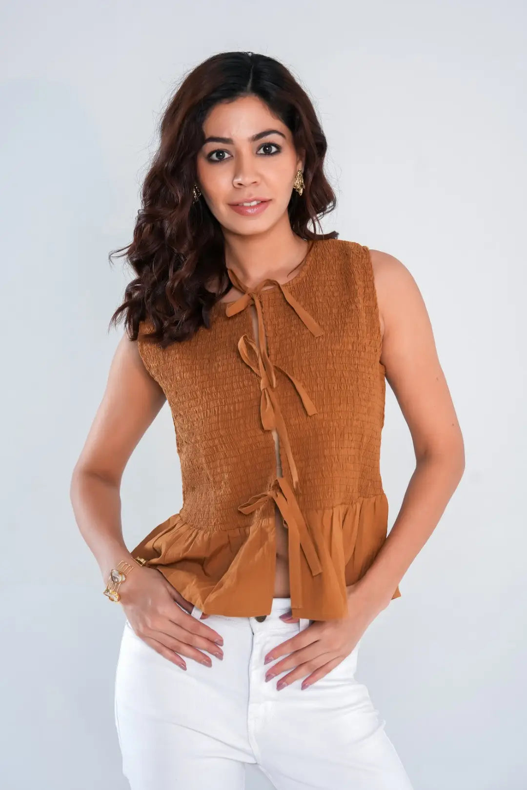 Close-up of brown sleeveless blouse in 100% lightweight cotton with tie-front and smocked design